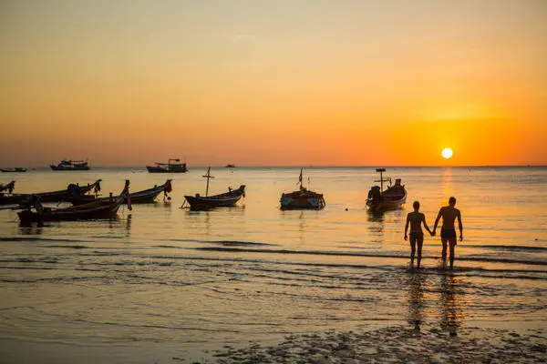 romance time for a loving couple walking on Sairee beach, the most beautiful sunset point in Thailand